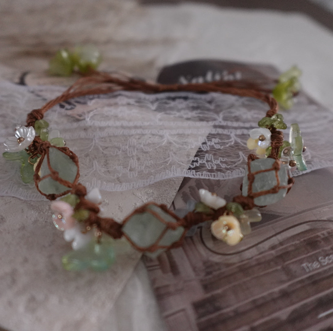 Green Fluorite Woven Bracelet featuring natural crystals and unique floral designs on a brown cord
