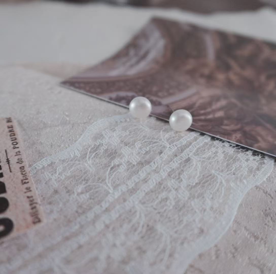 Natural Freshwater Pearl Oval Stud Earrings on a soft textured background with elegant photography