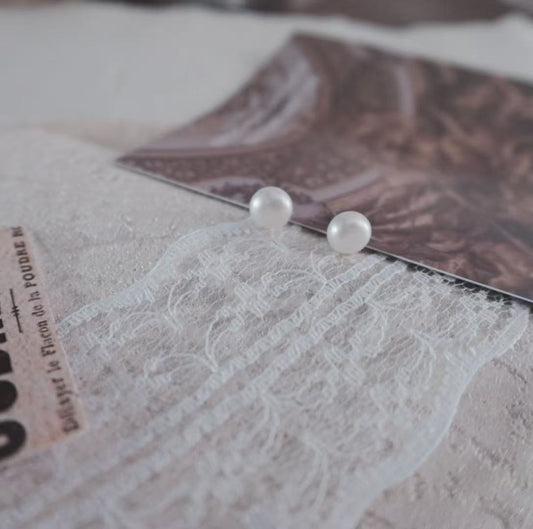 Natural Freshwater Pearl Oval Stud Earrings on a soft textured background with elegant photography