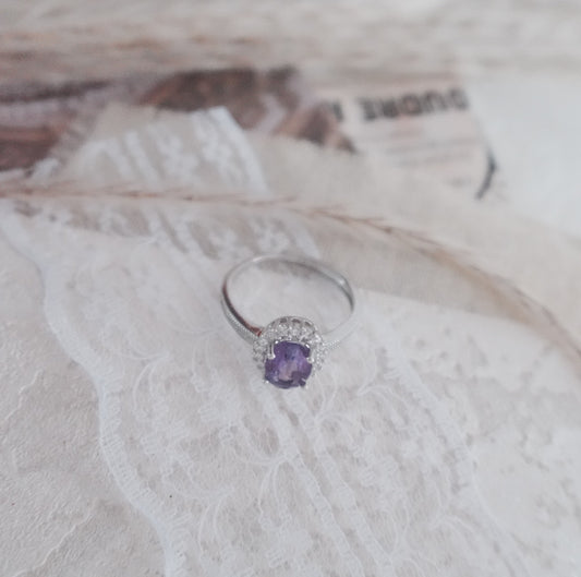 Elegant Oval Amethyst Diamond Ring with a sparkling gemstone and delicate setting on a lace background
