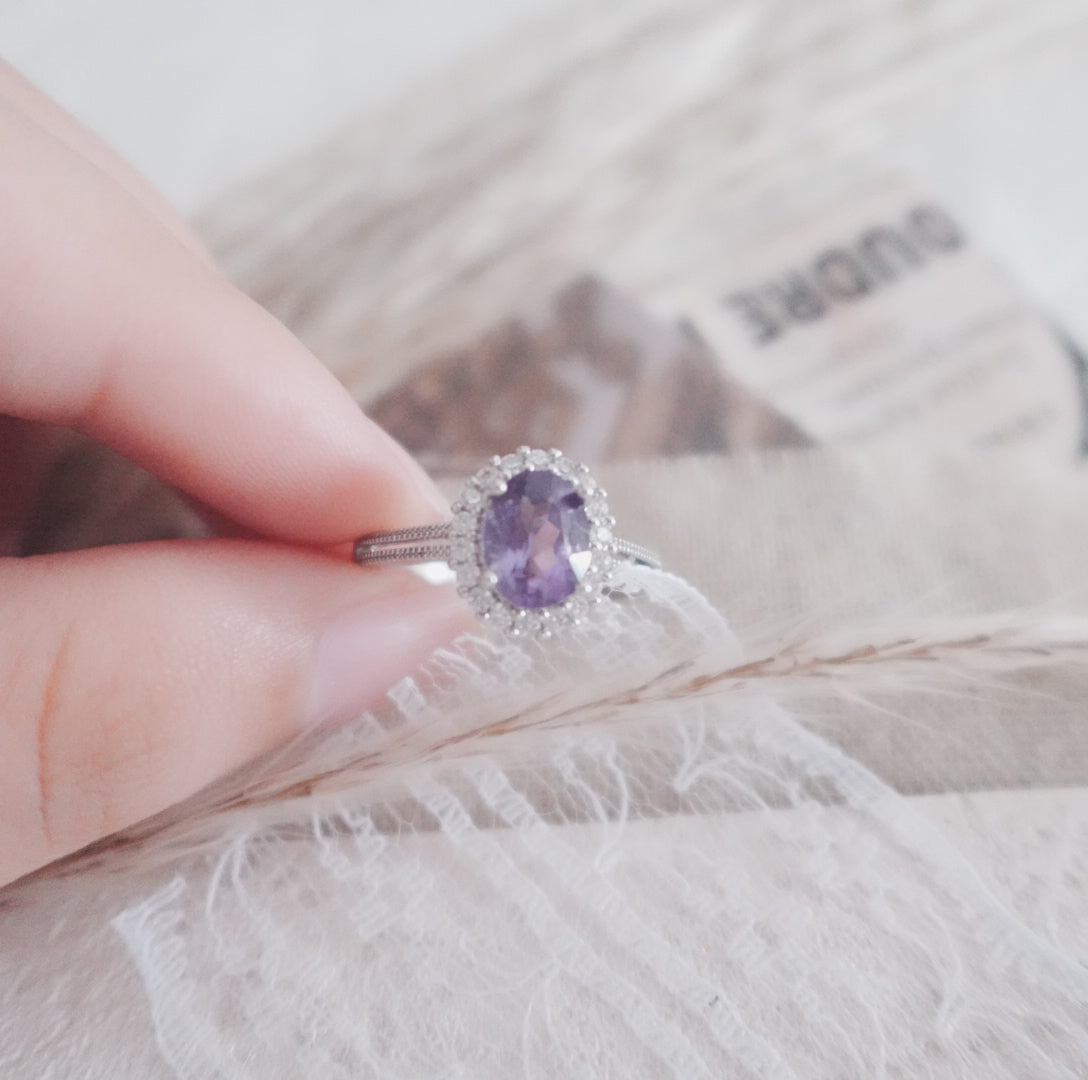 Stunning Oval Amethyst Diamond Ring with a delicate halo setting held in hand