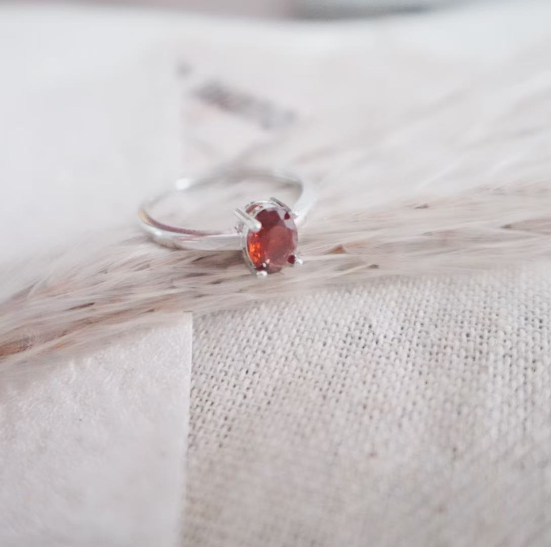 Elegant Oval Garnet Ring set in silver, showcasing a deep red crystal for a stunning look