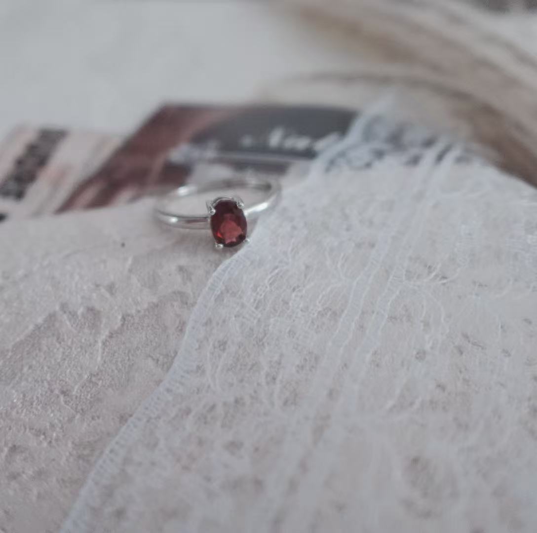 Elegant Oval Garnet Ring set in silver, showcasing a rich red gemstone for a timeless look