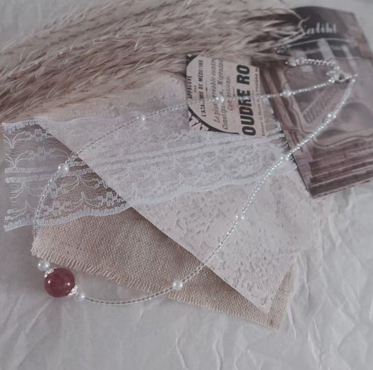 Strawberry Quartz Beaded Necklace with delicate silver accents on a textured background