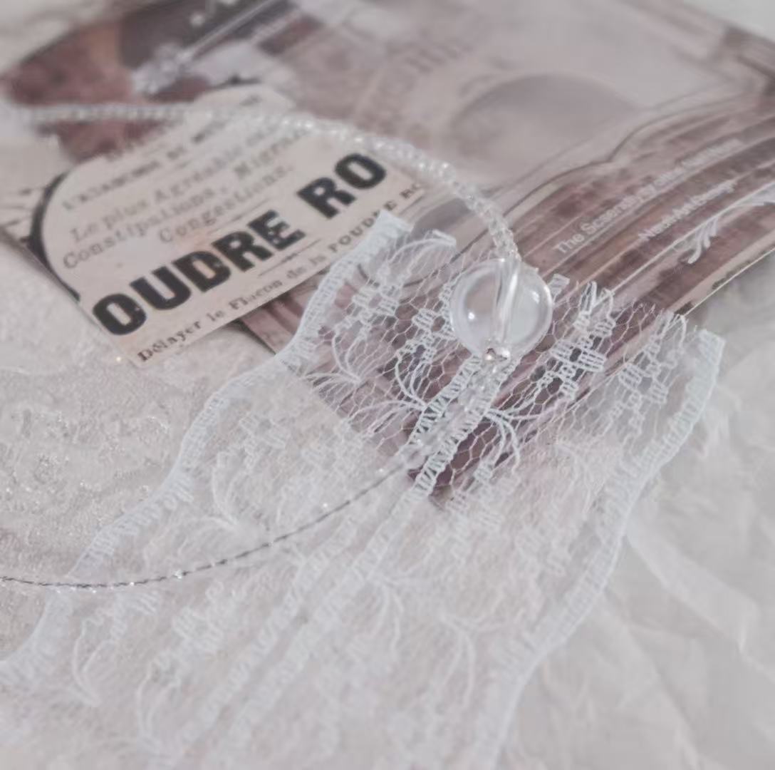Elegant White Crystal Beaded Necklace displayed on delicate lace background with a unique clasp