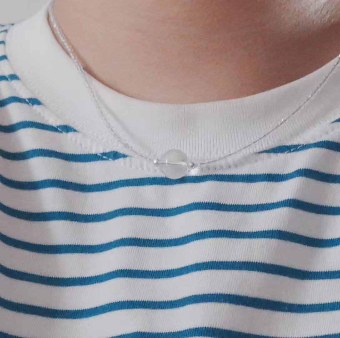 Elegant White Crystal Beaded Necklace displayed on a model with a striped shirt