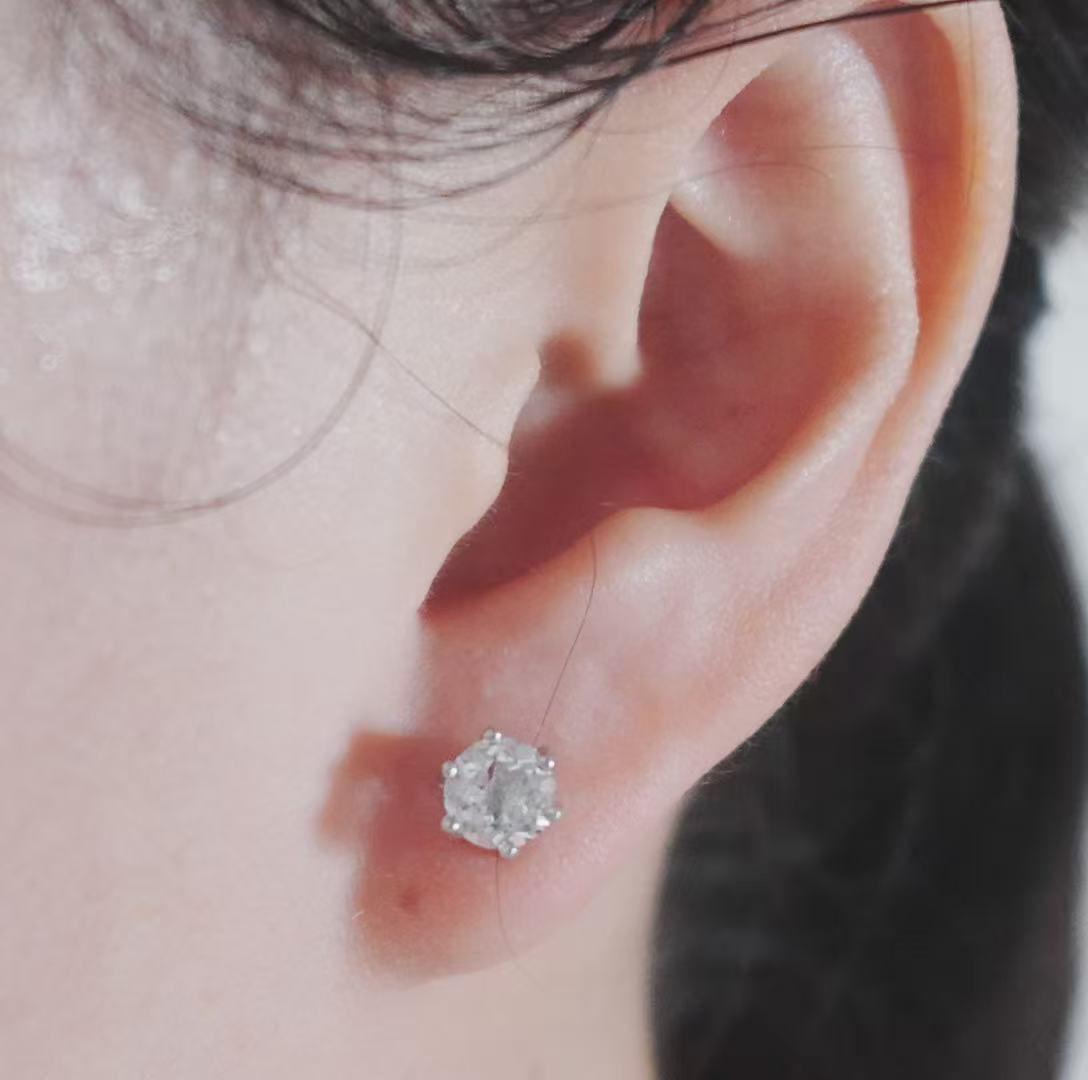 Elegant White Crystal Faceted Stud Earrings displayed on a model's ear for a sparkling look
