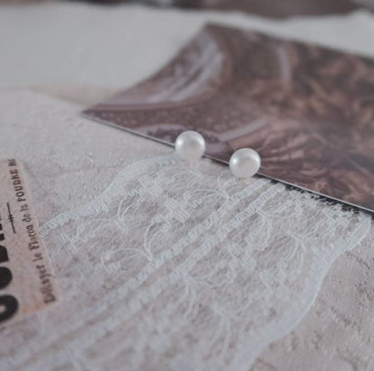 Natural Freshwater Pearl Oval Stud Earrings on a soft textured background with elegant photography