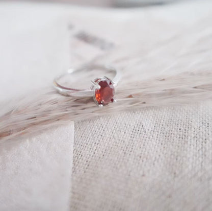 Elegant Oval Garnet Ring set in silver, showcasing a deep red crystal for a stunning look
